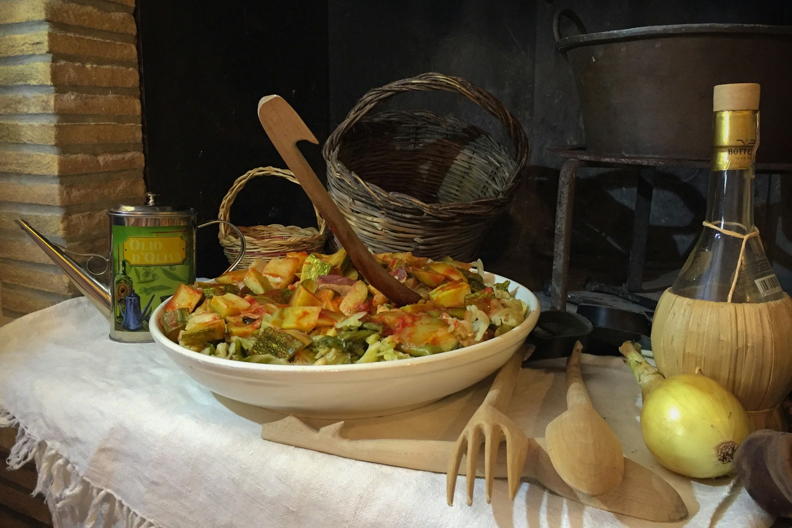 A traditional Italian preparation of baccal&agrave; &mdash; salt cod &mdash; being plated with chopped parsley, capers and a drizzle of olive oil on a white ceramic platter, with lemon wedges visible at the edges.