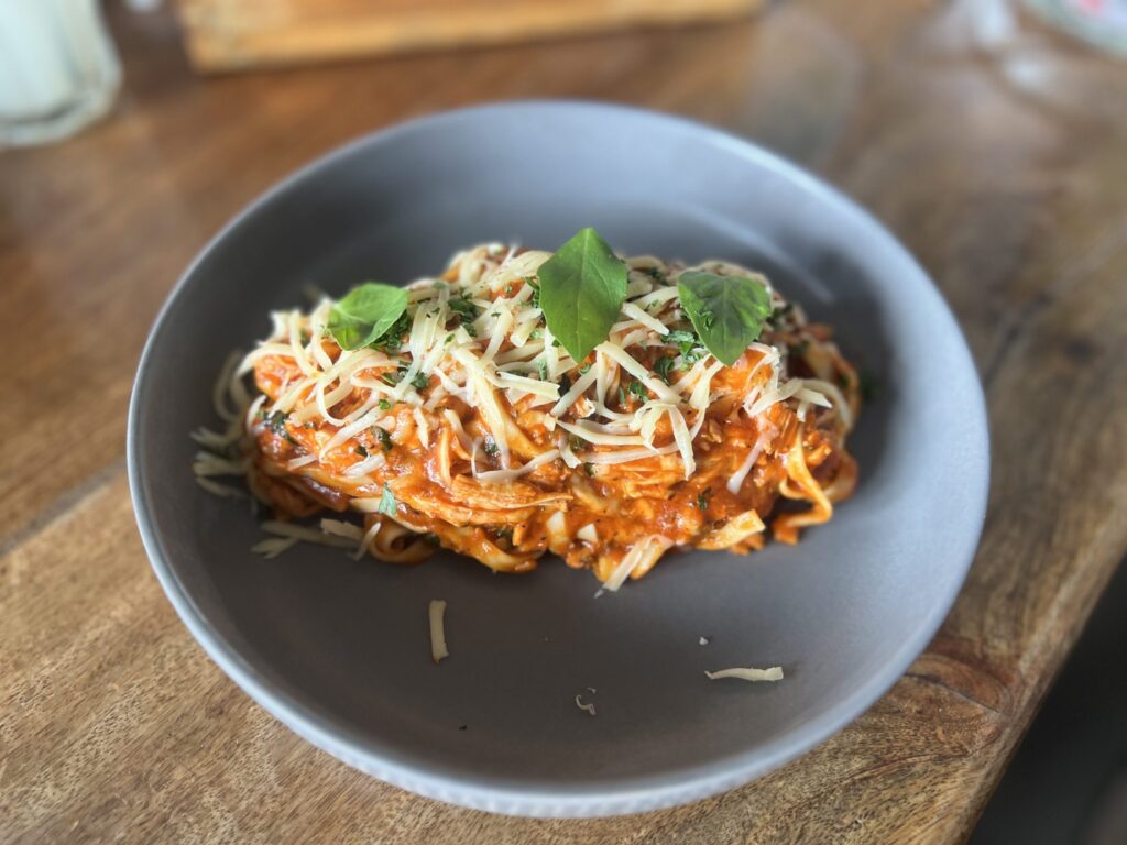 Piatto di spaghetti conditi a crudo con olio e prezzemolo tritato sopra