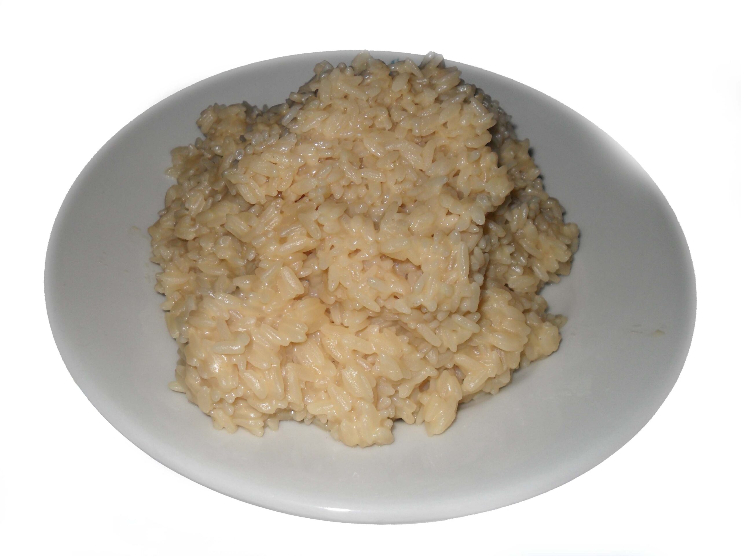 Piatto fondo di risotto cremoso con fette di funghi porcini rosolati e prezzemolo tritato