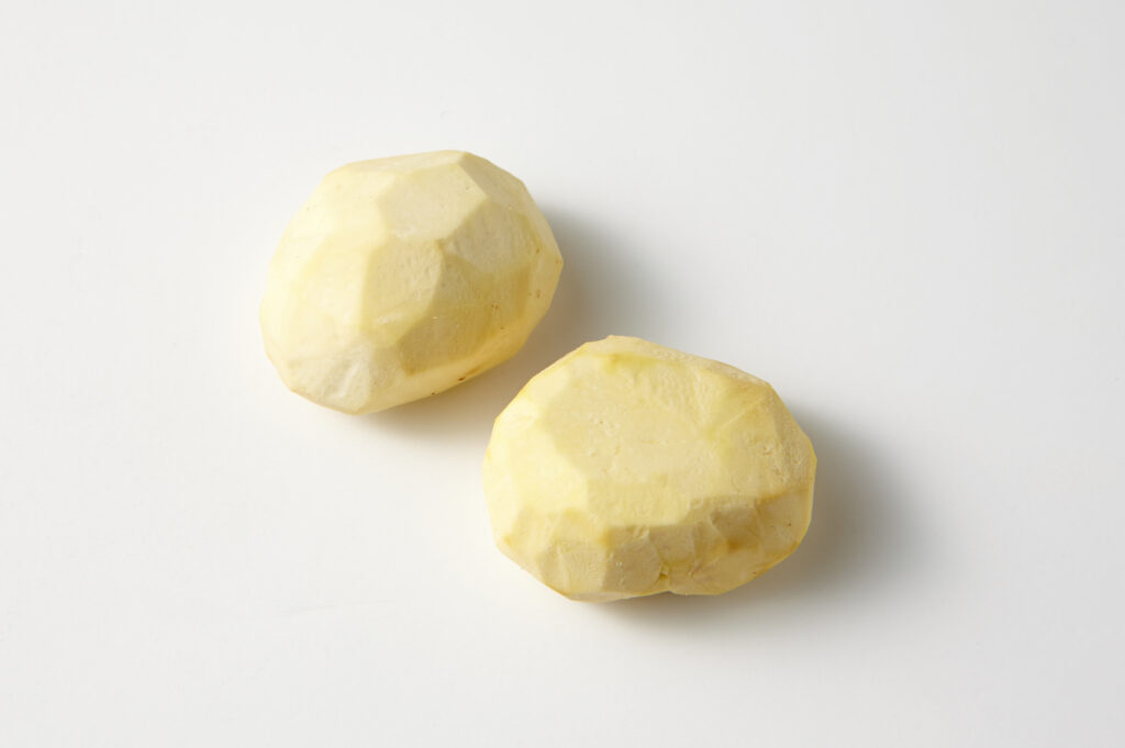 Castagne lessate e sbucciate su un canovaccio bianco accanto a un coltellino corto